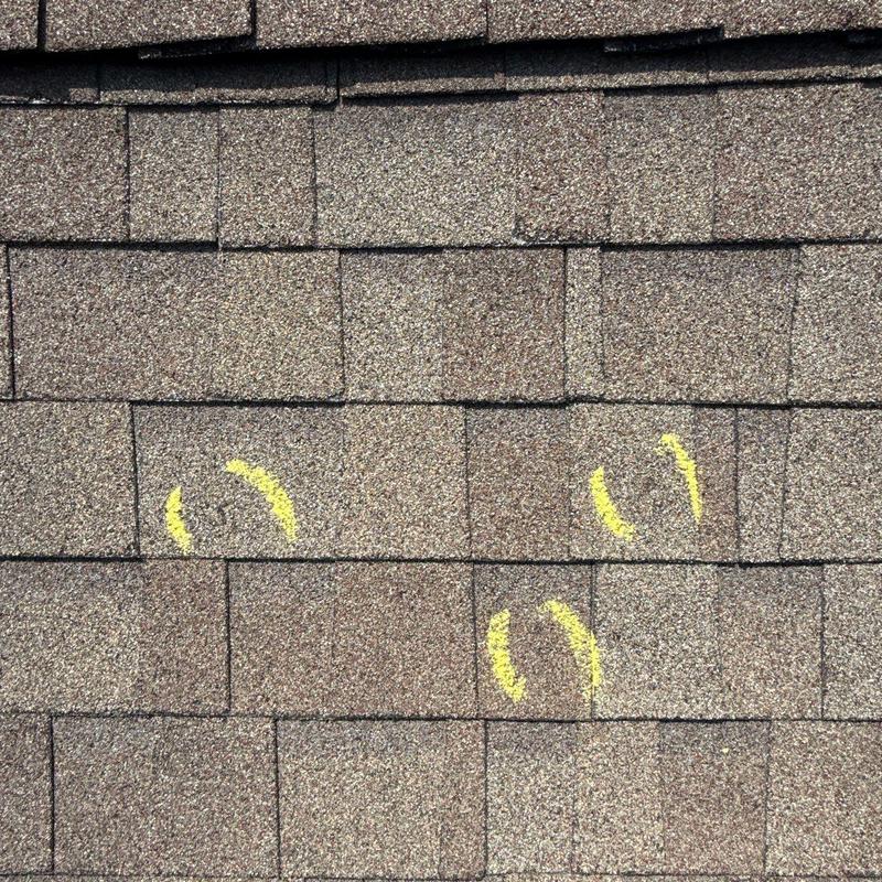 Asphalt roof shingles with hail damage markings