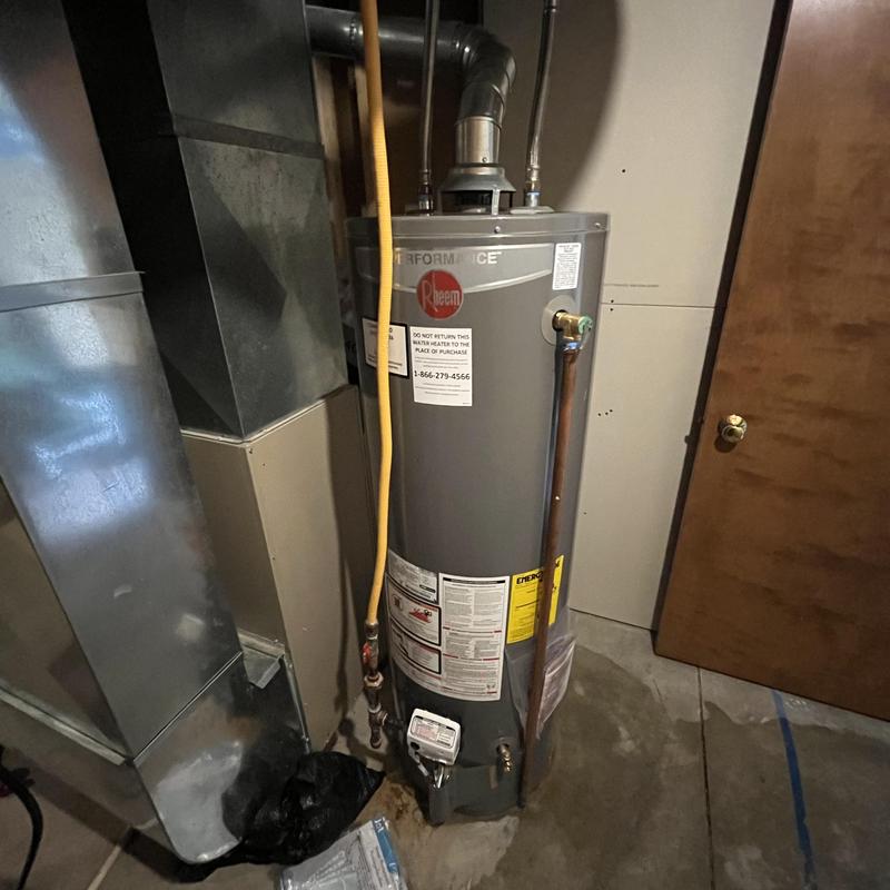 Rheem water heater with vent and piping in basement