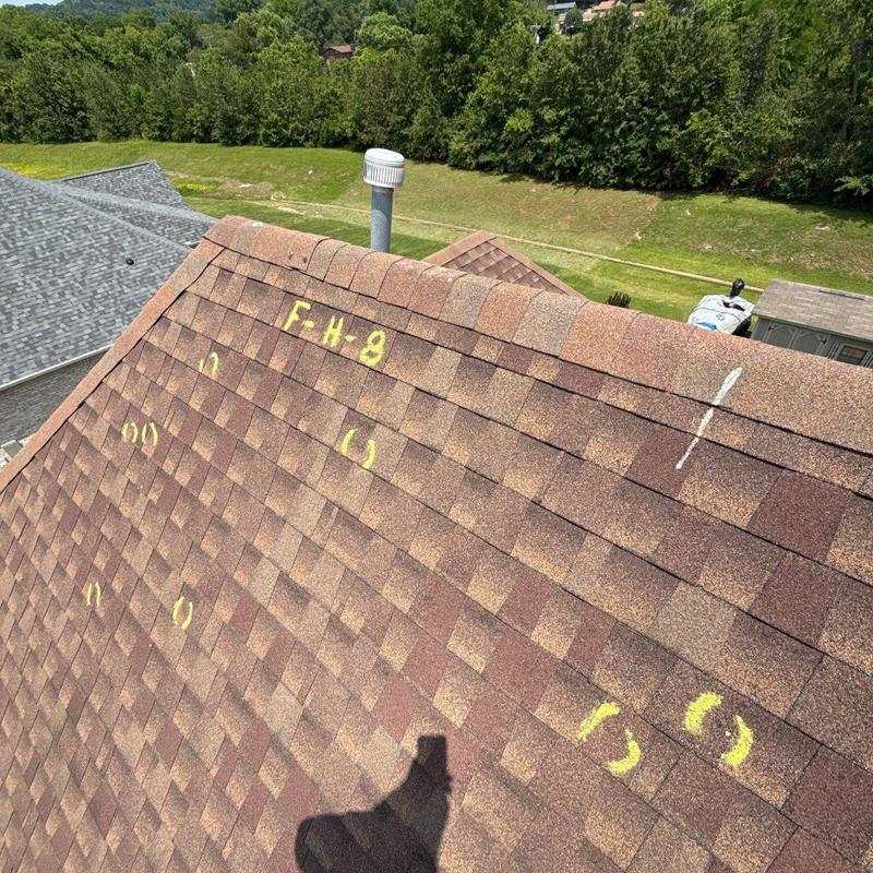 Roof shingles with hail damage markings on slope
