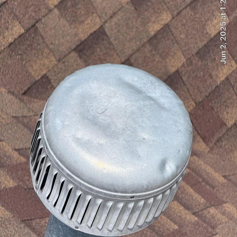 Roof vent cap with dents on shingle roof surface