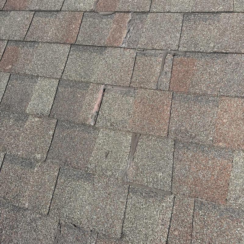 Asphalt shingles with hail impact and wind damage