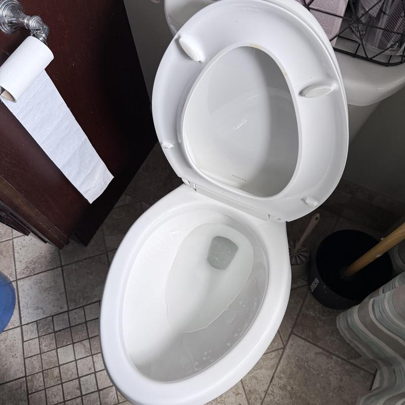 Toilet bowl with open lid in bathroom setting Toilet bowl with open lid in bathroom setting