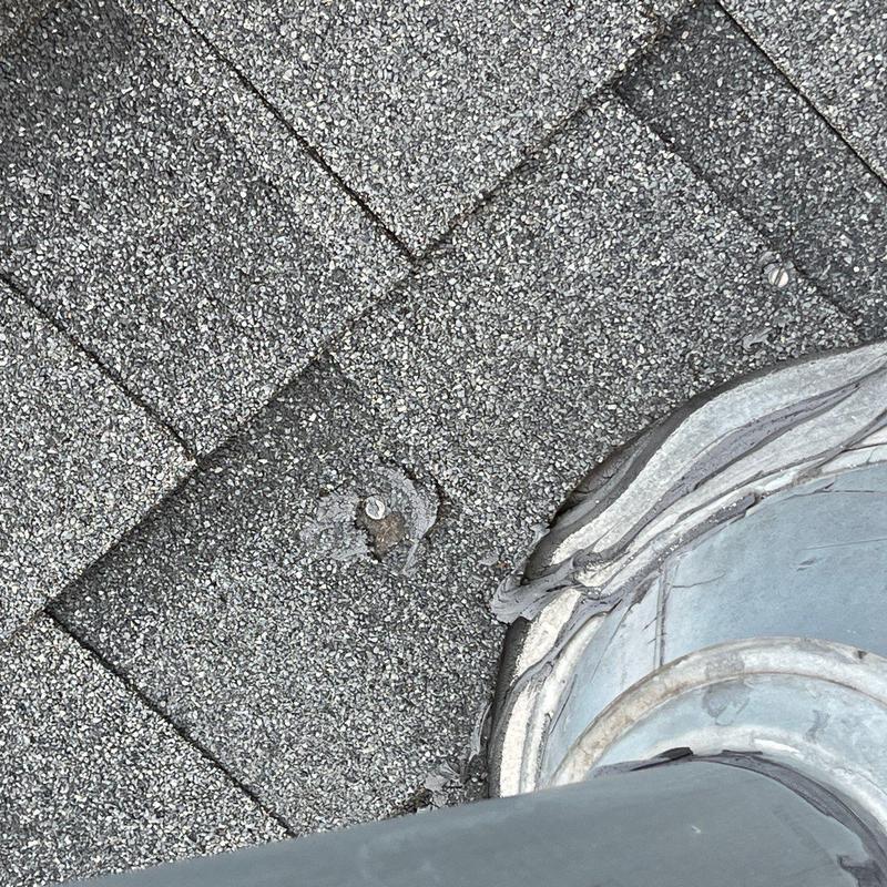 Roof shingles with hail damage near pipe flashing