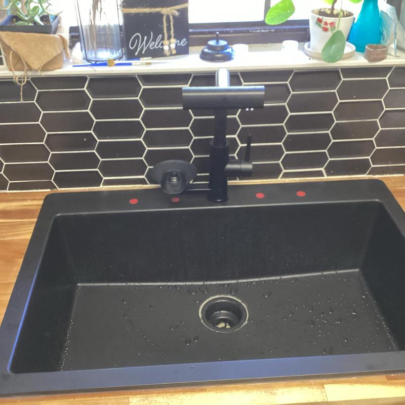 Black granite kitchen sink with modern faucet installed