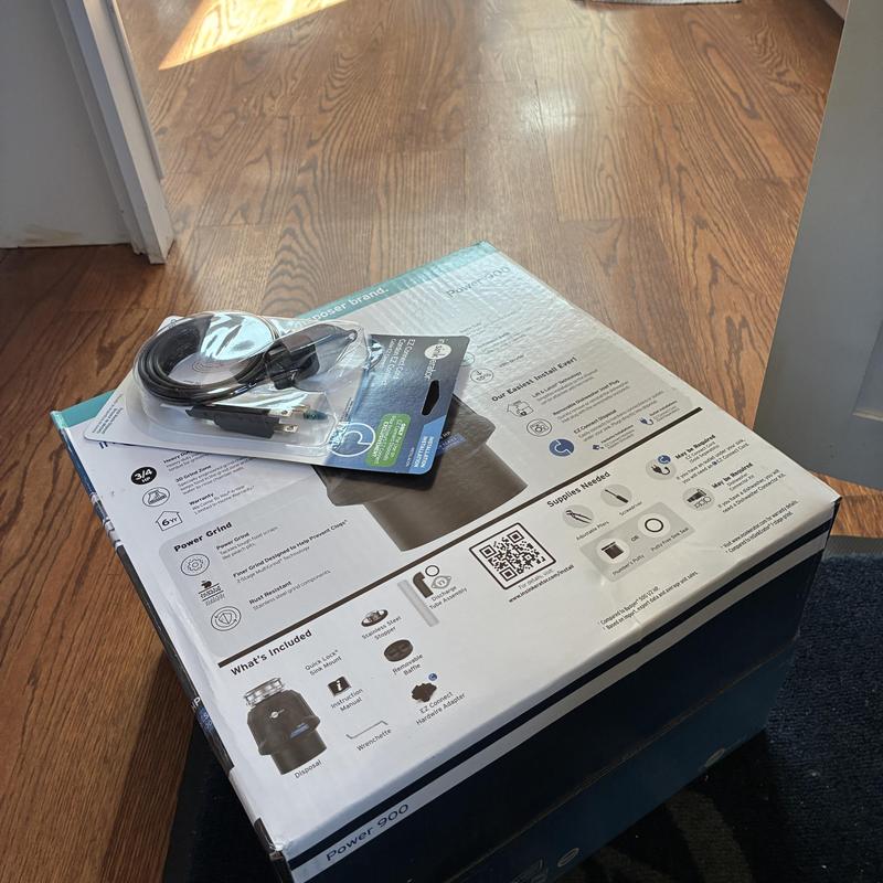 Garbage disposal unit with power cord on packaging