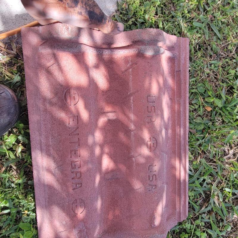 Concrete tile roof tile with visible cracks on grass