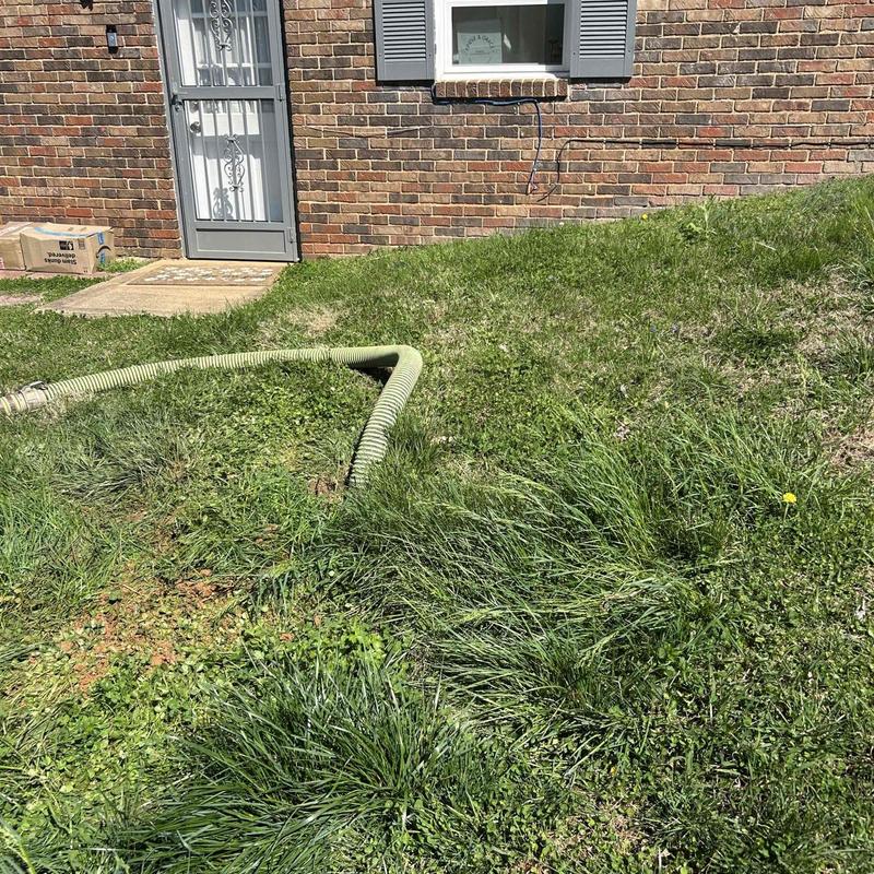 Septic tank hose setup outside brick house in Chattanooga