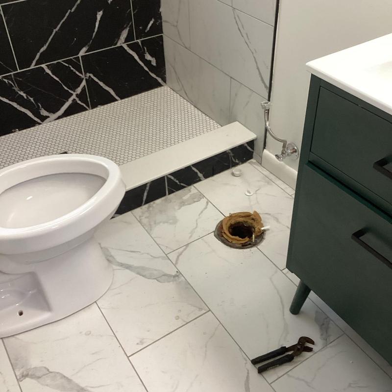 Toilet flange with removed toilet in bathroom remodel