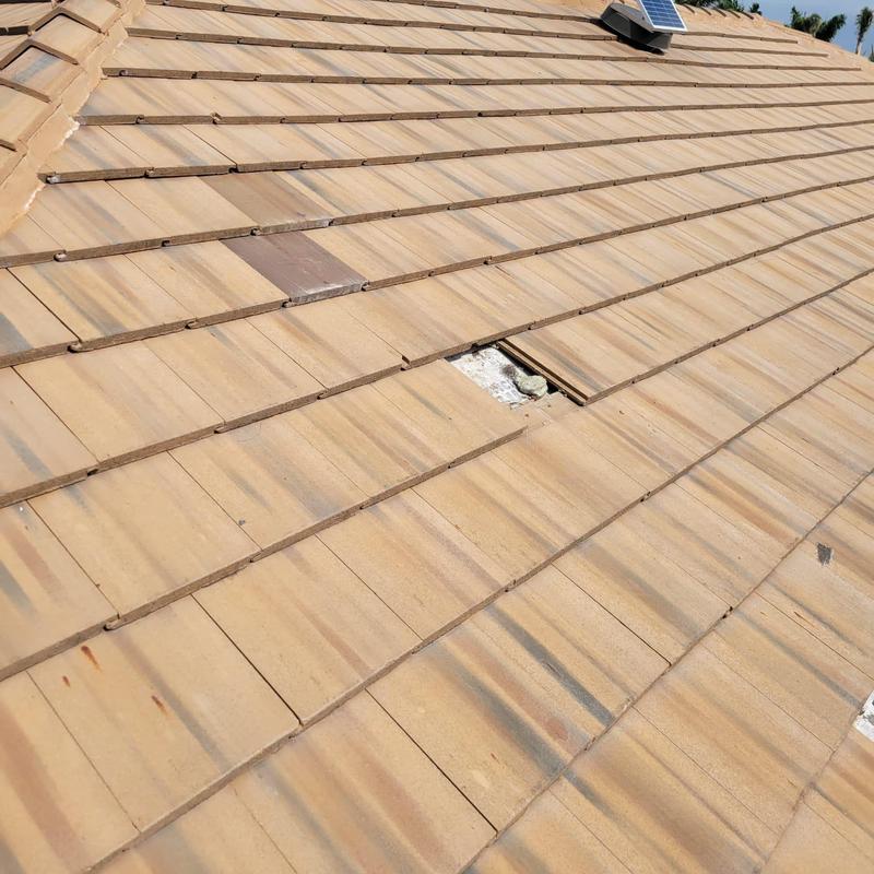 Concrete tile with broken and replaced roof tiles
