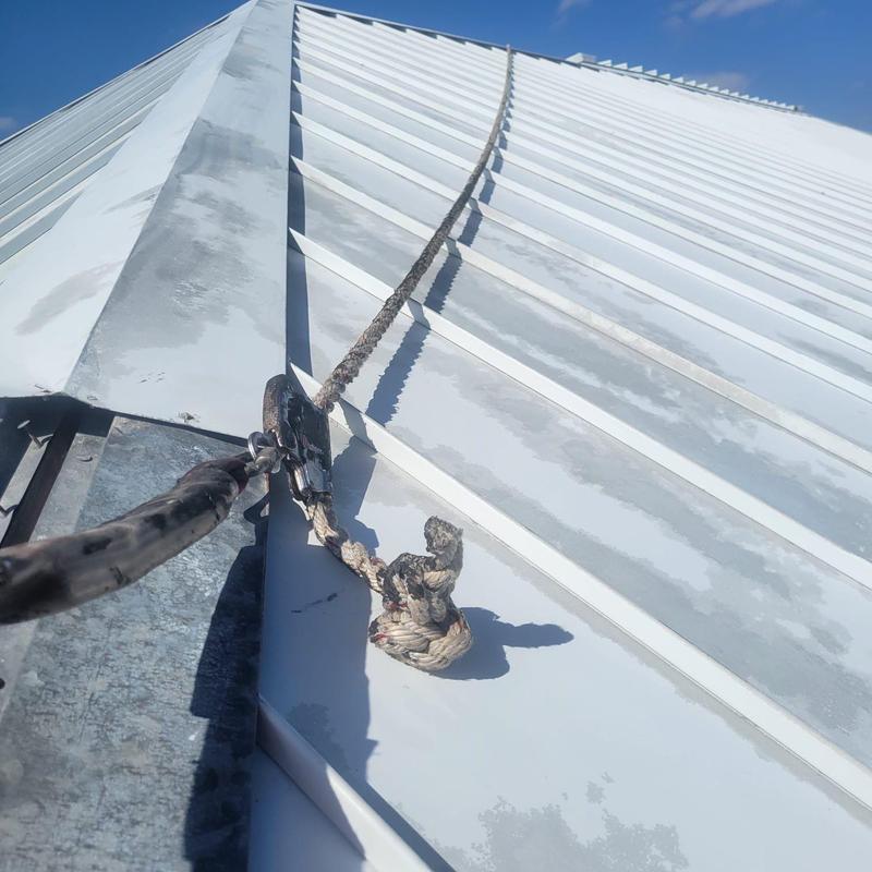 Standing seam metal roof with safety tie-off rope