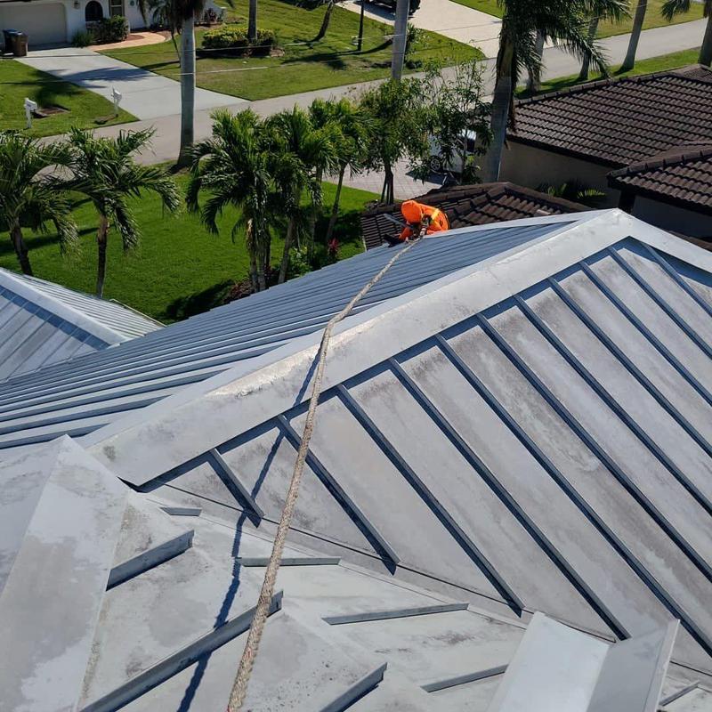 Standing seam metal roof with safety rope and worker