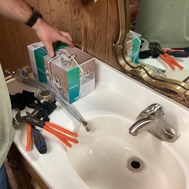 Bathroom sink faucet with installation tools on countertop