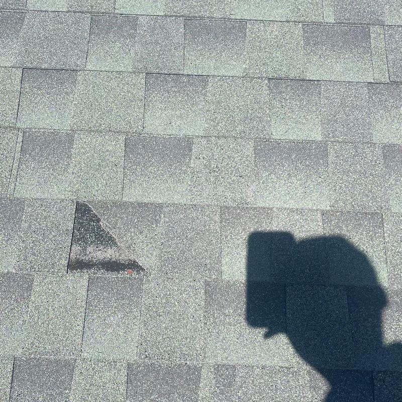 Asphalt shingle roof with missing cap shingles