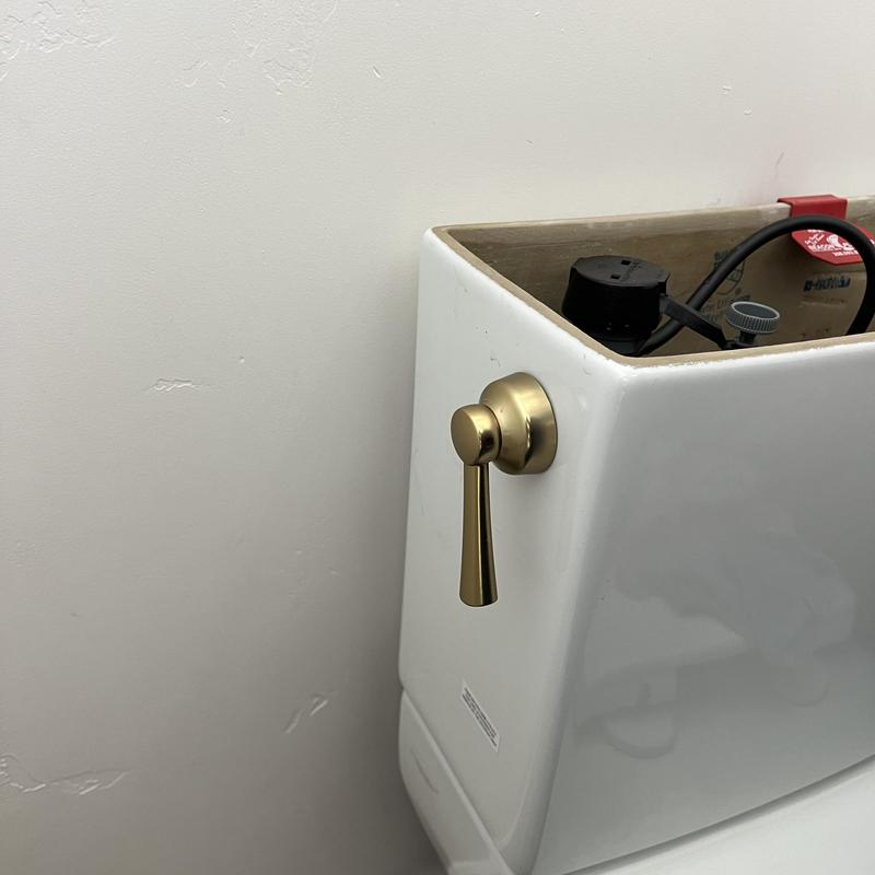 Toilet tank with new gold handle installed