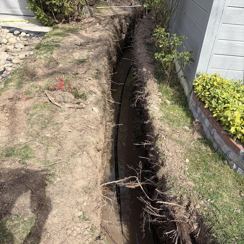 1-inch Watermain installation trench by house wall 1-inch Watermain installation trench by house wall
