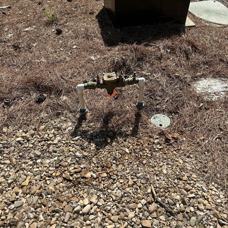 Valve backflow preventer with PVC piping outdoors