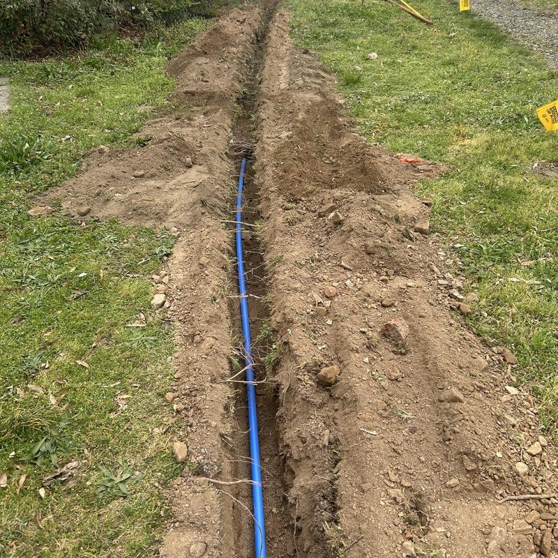 Water service line with new blue piping in trench Water service line with new blue piping in trench