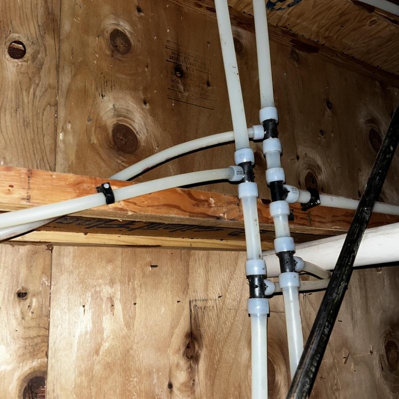 Pex piping with connectors in crawl space plumbing