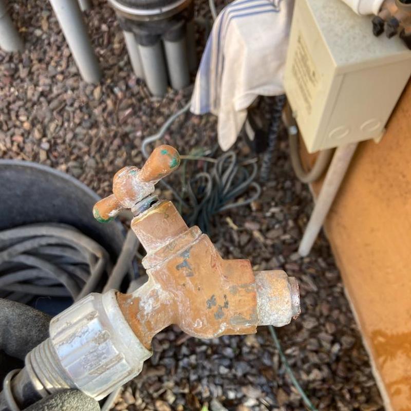Corroded outdoor hose bibb faucet in backyard
