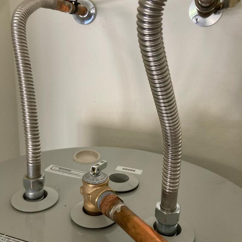Water heater with flexible metal connectors and safety valve