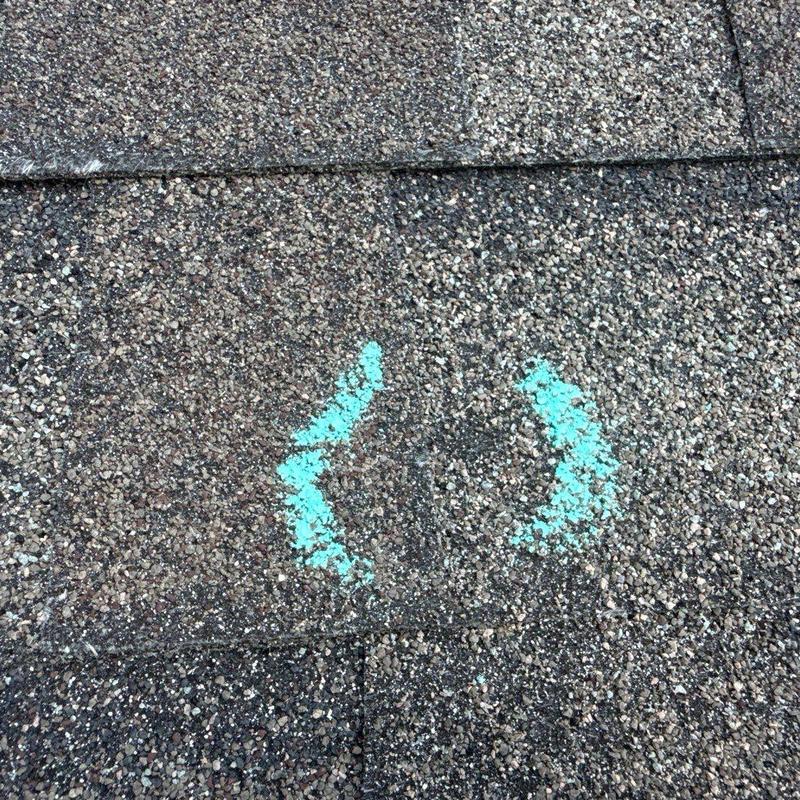 Asphalt shingle roof hail damage marked for inspection