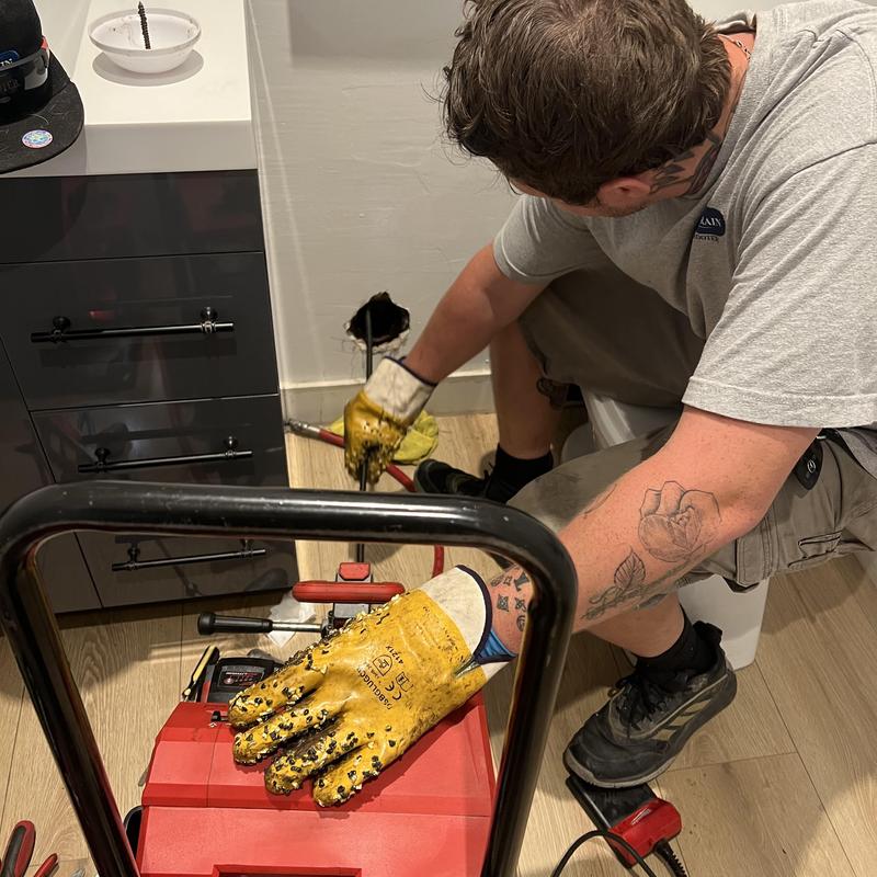 Main sewer line hydro jetting with technician gloves