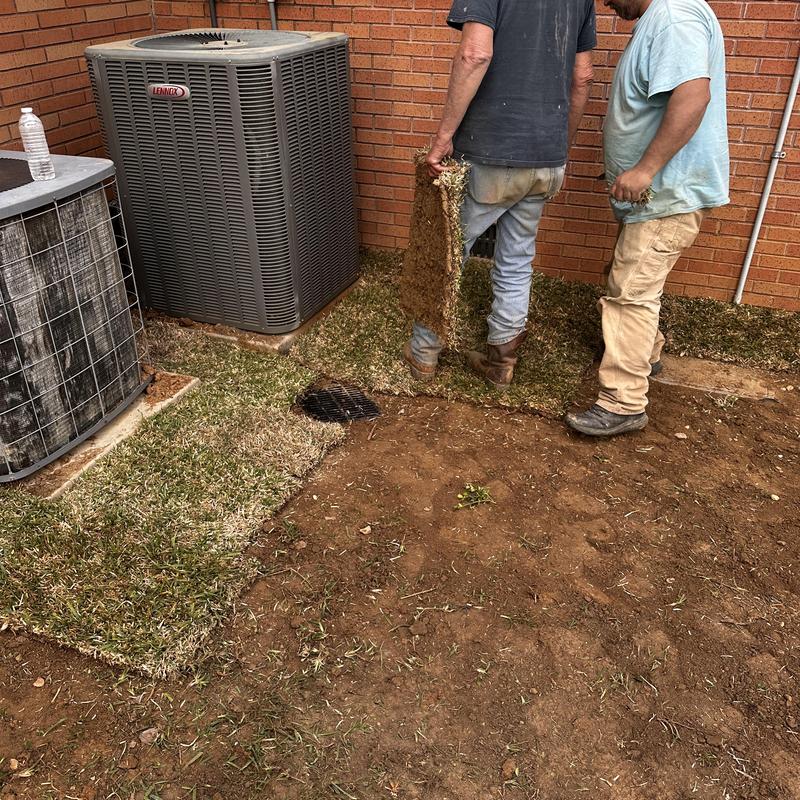 French drain installation with sod near HVAC units