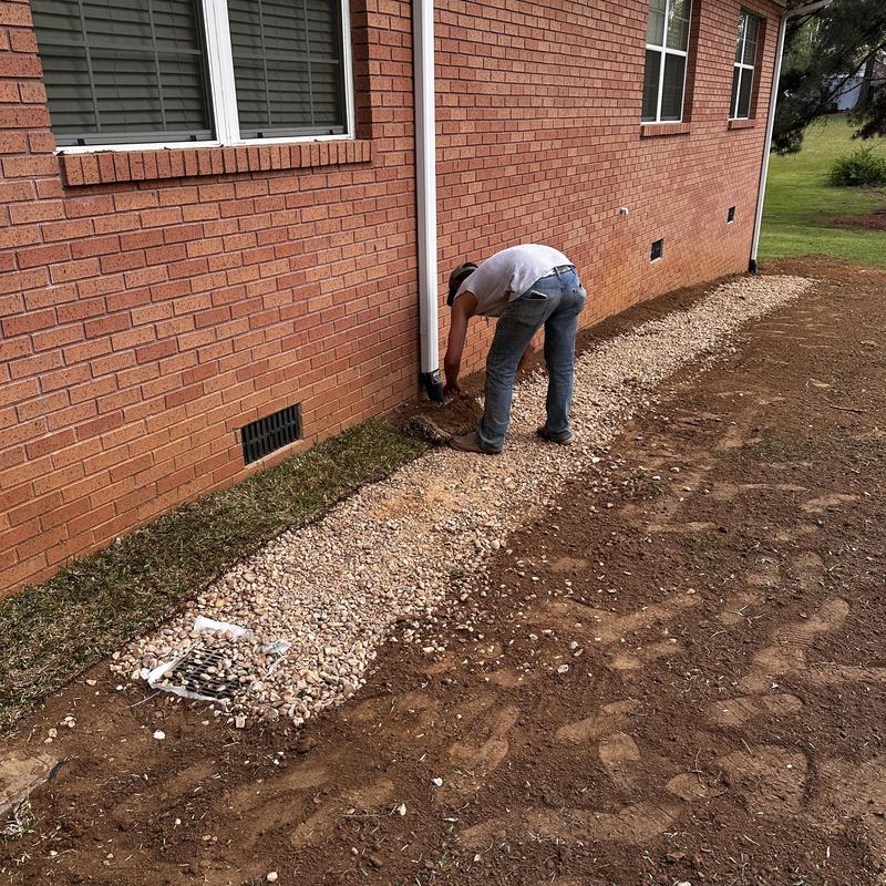 Perforated French drain pipe with gravel bed installation