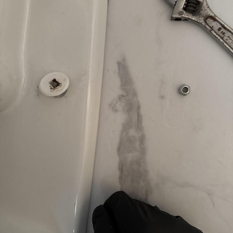Kohler toilet bolt and wrench on floor next to tub