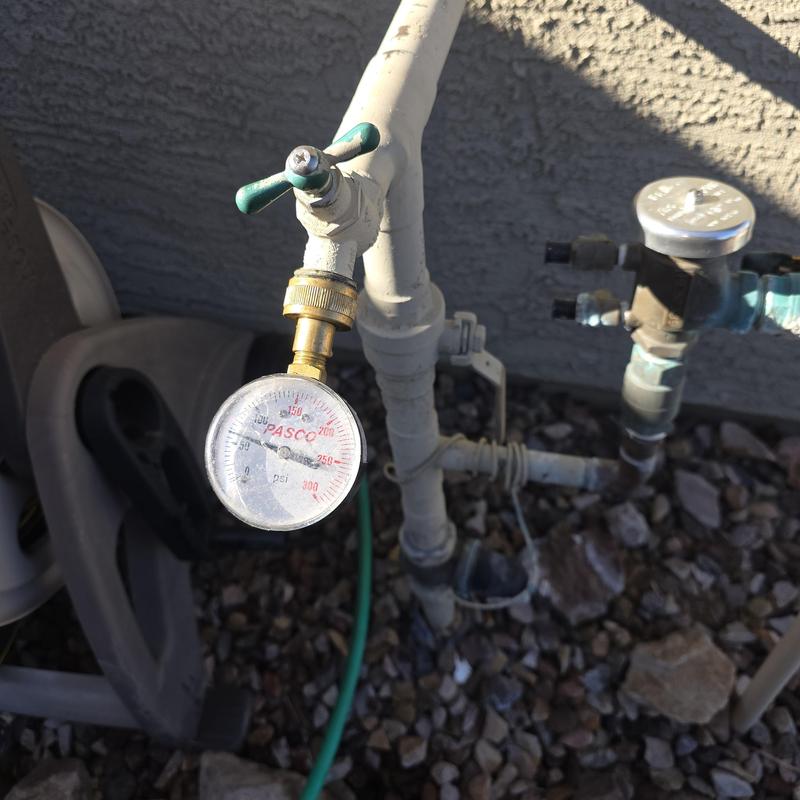 Pressure reducing valve with attached pressure gauge in outdoor plumbing Pressure reducing valve with attached pressure gauge in outdoor plumbing