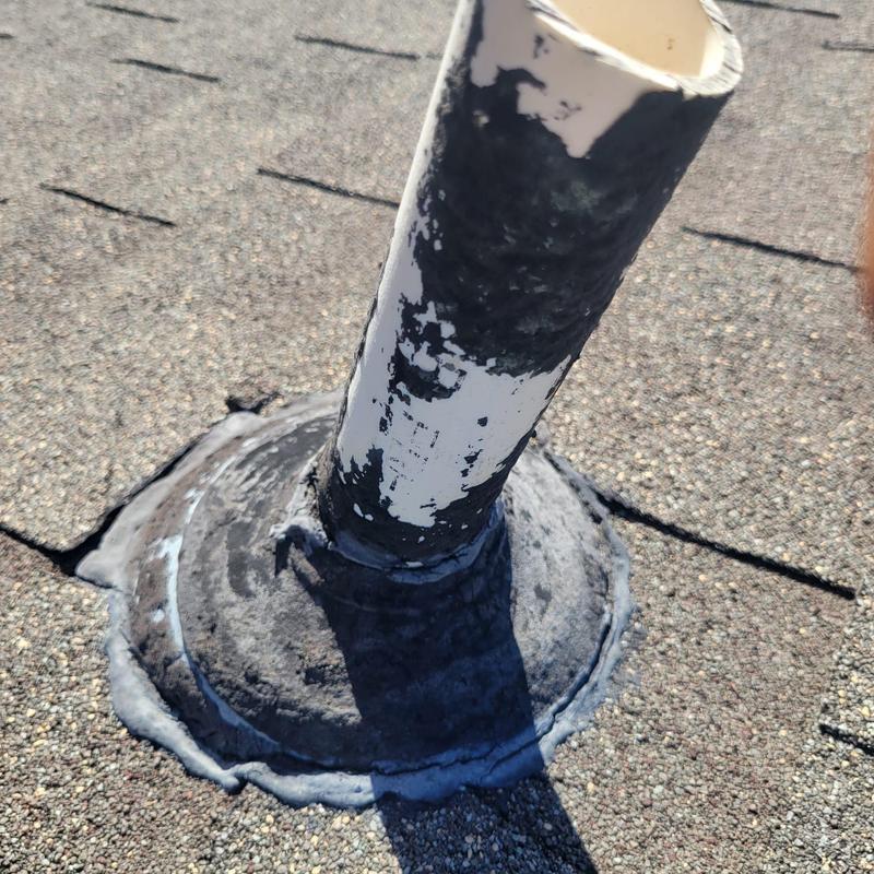 Roof pipe flashing with worn sealant on shingle roof