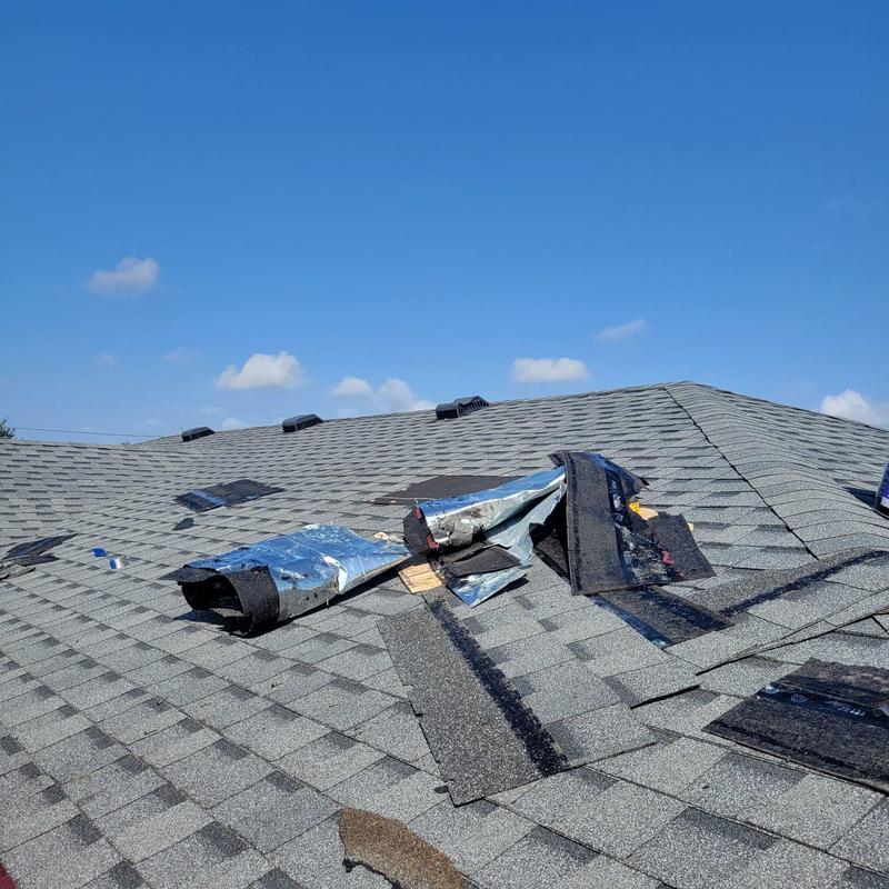 Shingle roof with torn underlayment and damaged shingles