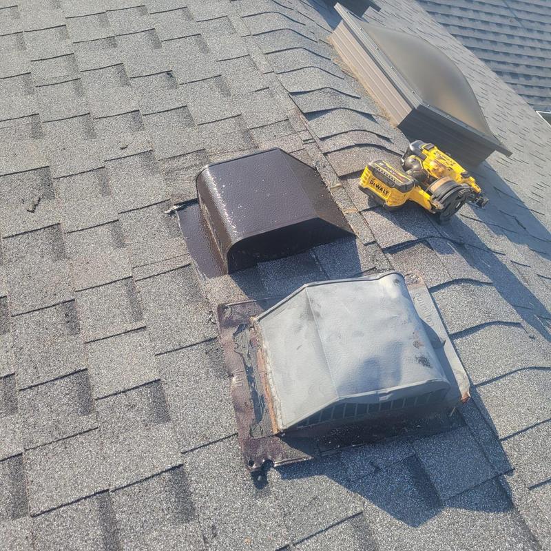 Roof vents on shingle roof with repair tools nearby