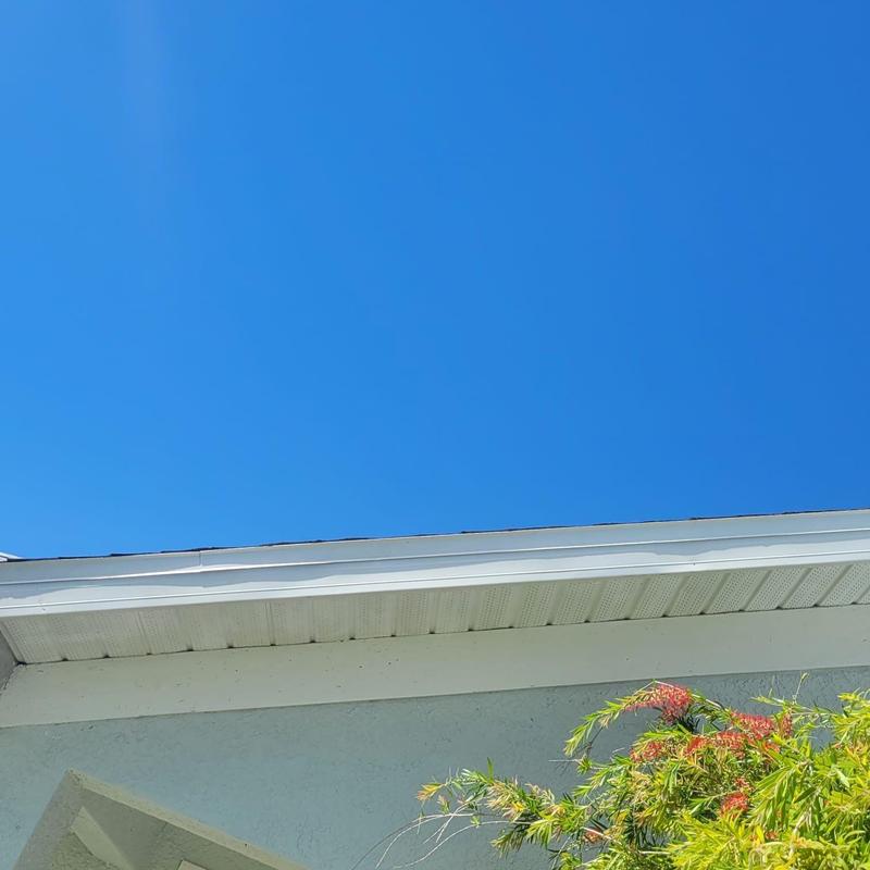 Soffit replacement under shingle roof with clear sky