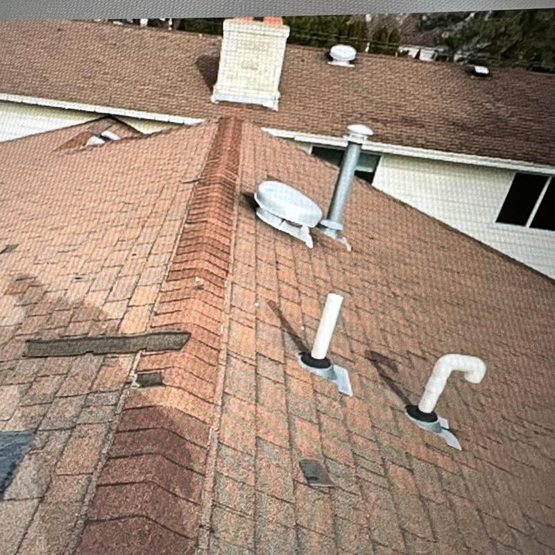 Roof shingles with storm damage and vent pipes