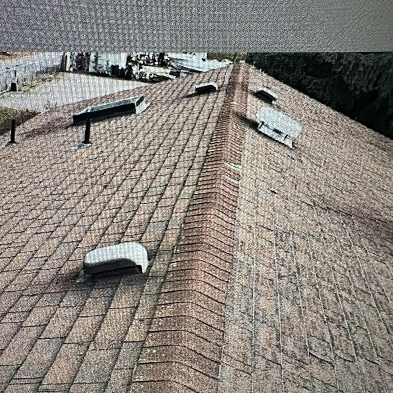 Shingle roof ridge with vent and weathering damage