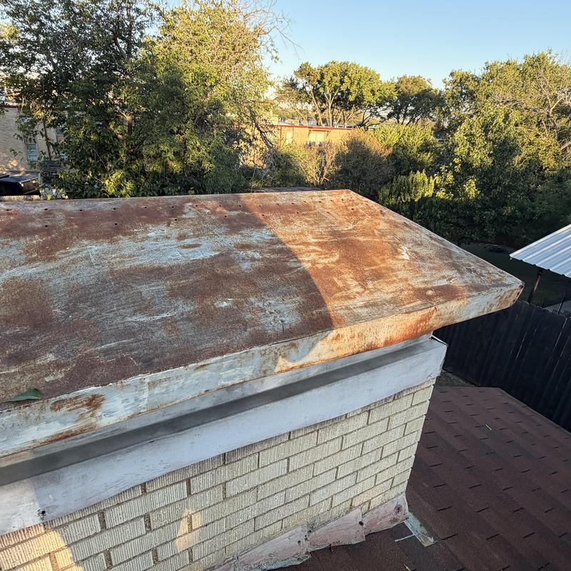 Chimney cap with rust and weathering damage