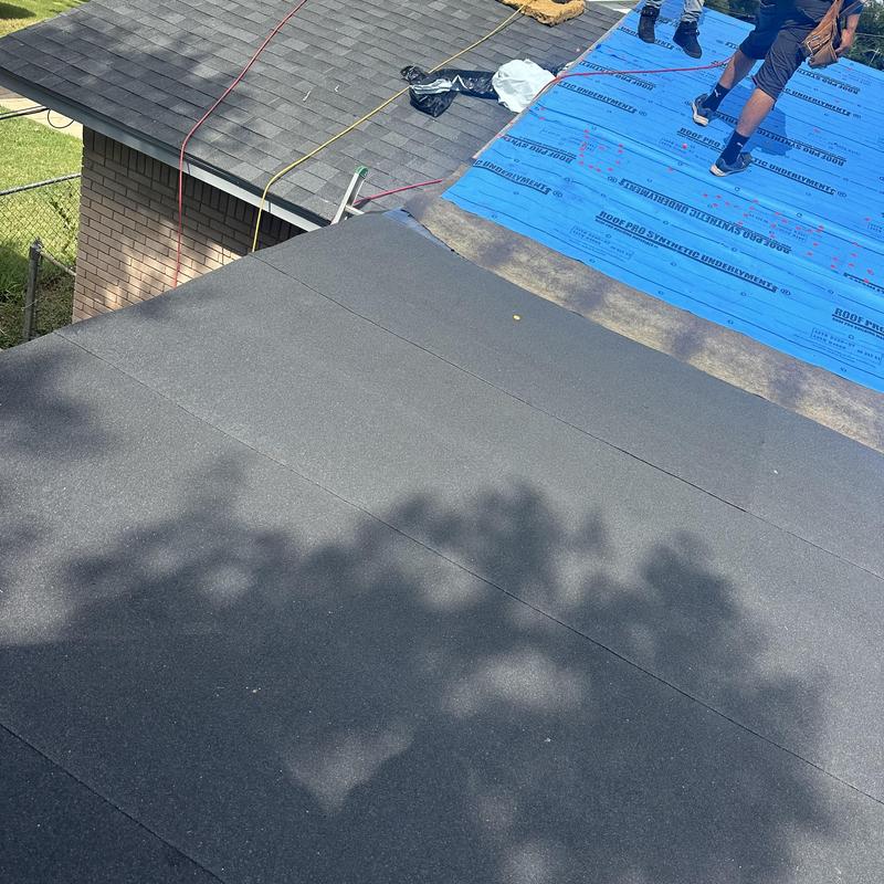 Flat roof installation with black underlayment in progress