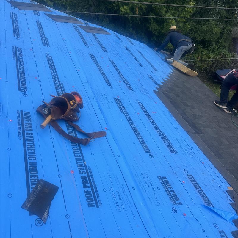Synthetic roofing underlayment installation with tools on roof