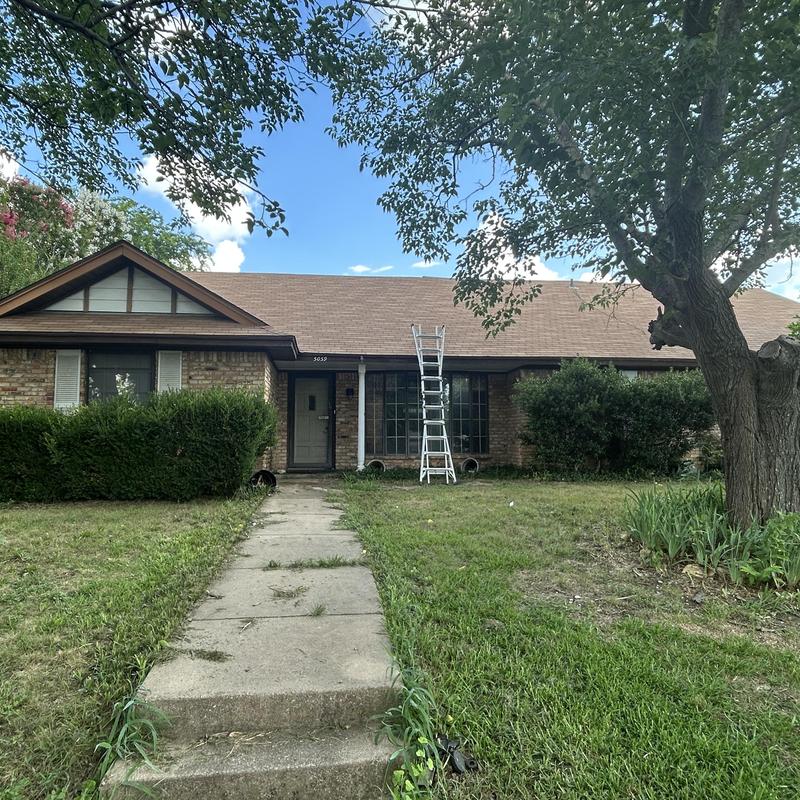 Asphalt shingle roof inspection with ladder at house