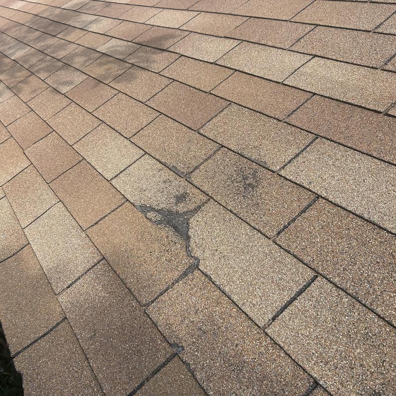 Asphalt roof shingles with visible damage and wear
