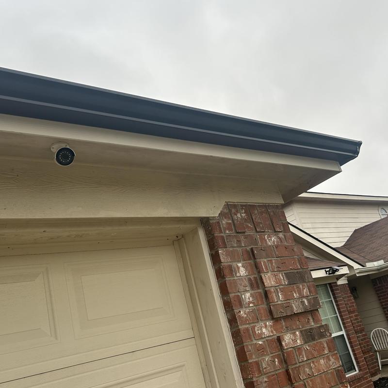 Black gutter and downspout installation on brick home