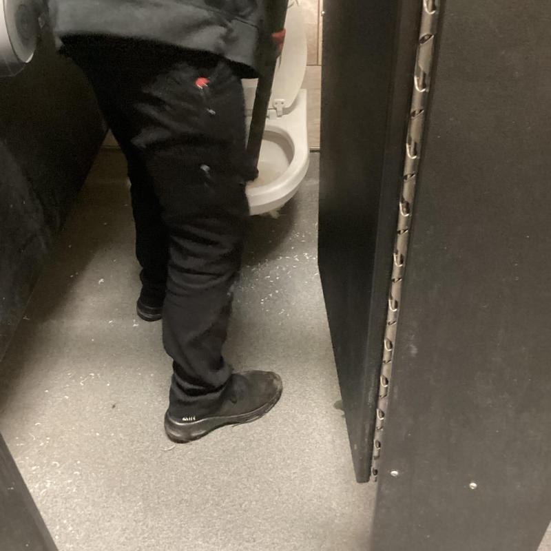 Toilet plumbing clog clearing in restroom stall