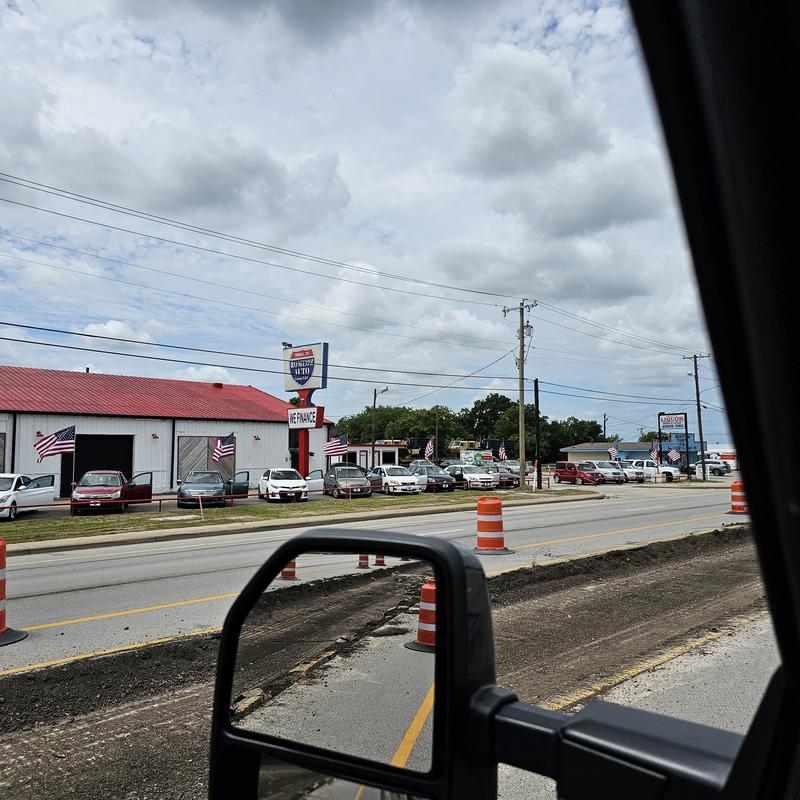 Road construction with traffic barrels near auto shop