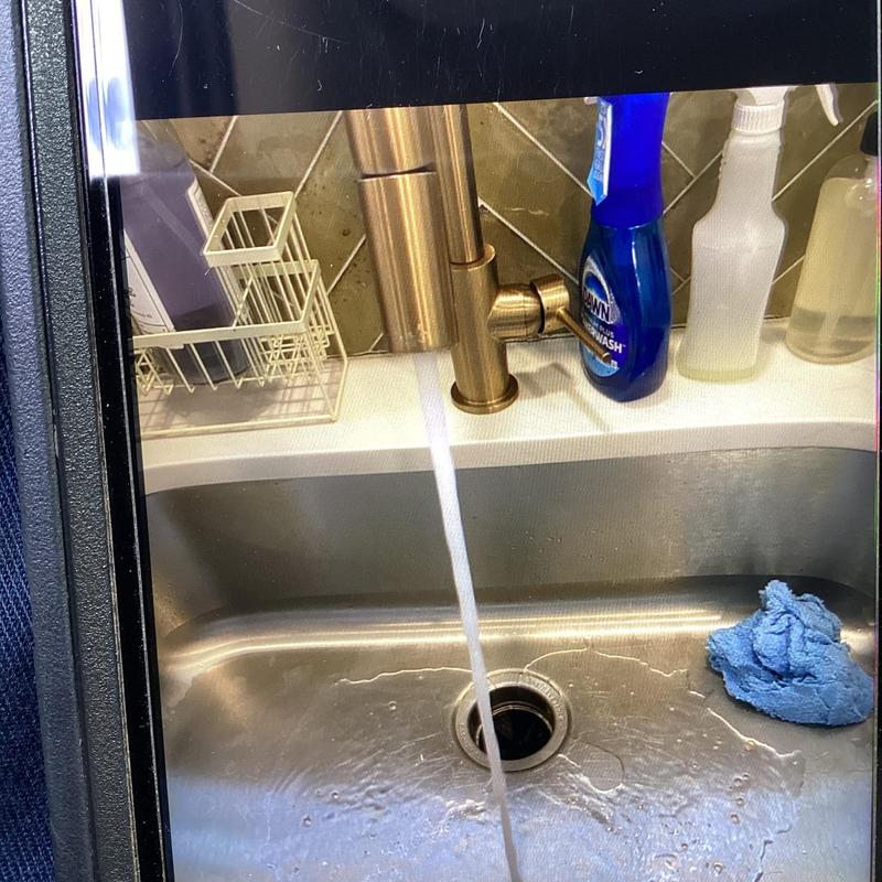 Kitchen sink drain flowing with water during cleaning check