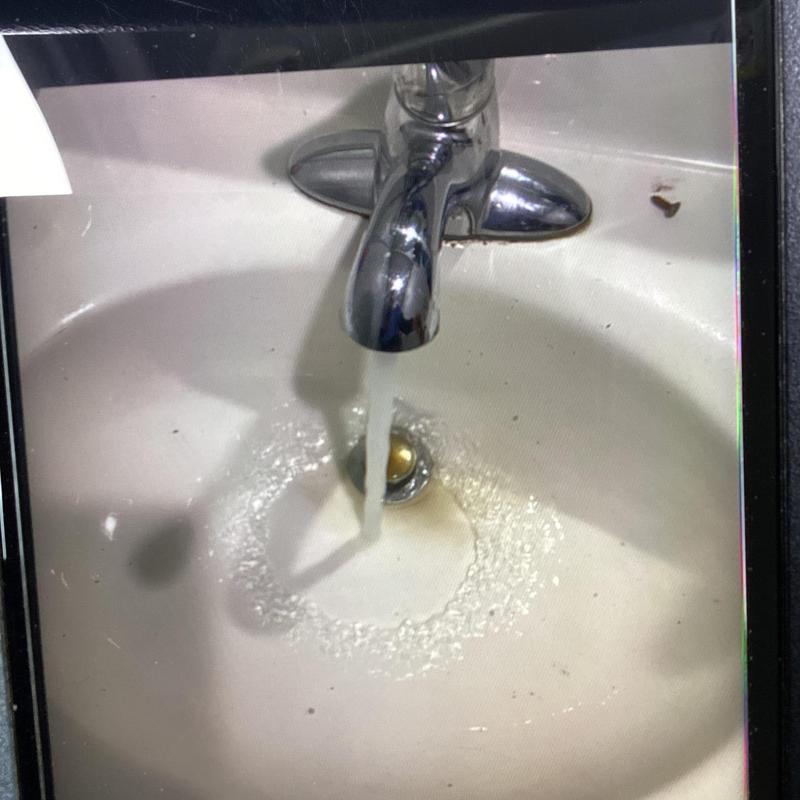 Bathroom sink drain clearing with running water test