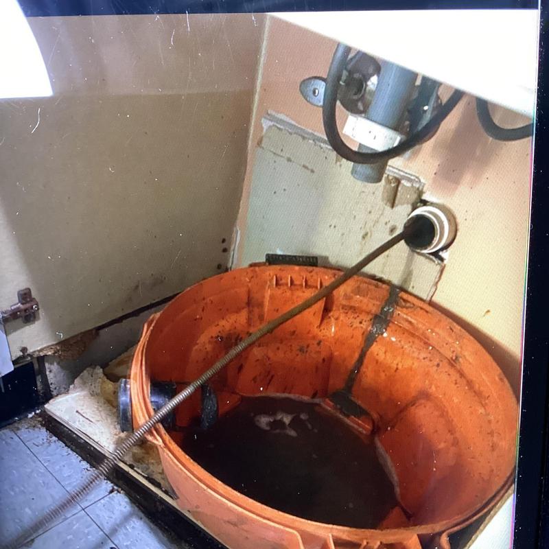 Bathroom drain cleaning with electric cable and bucket