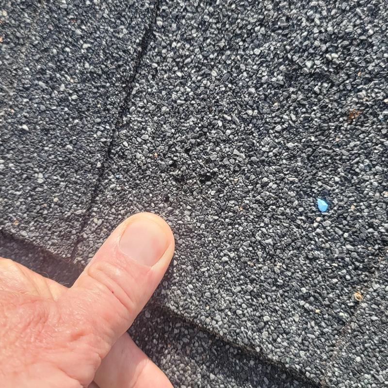 Asphalt roof shingles with hail damage close-up
