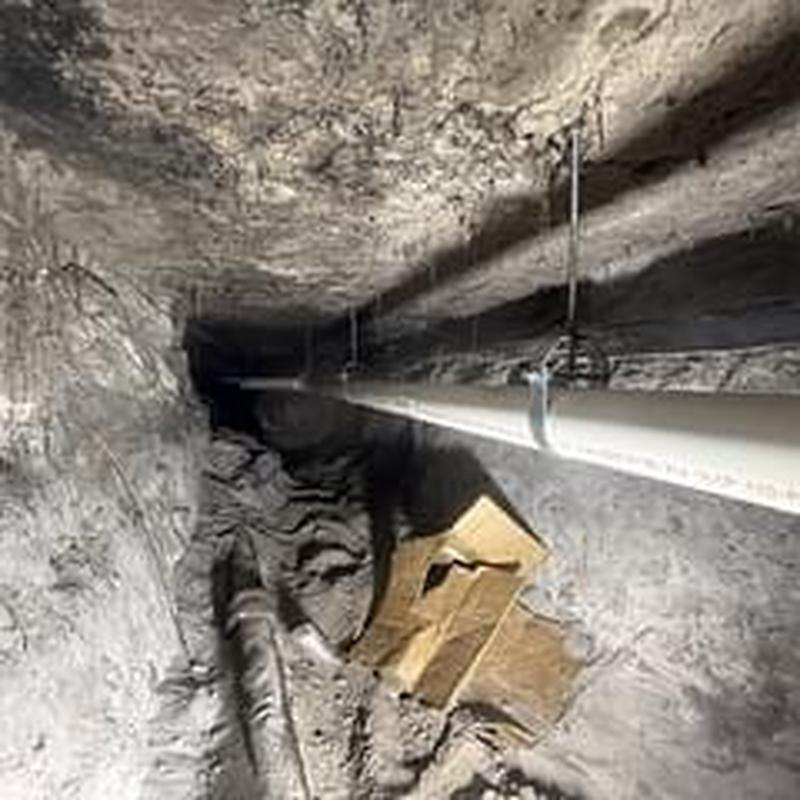 PVC drainage pipe installation in crawlspace with hangers