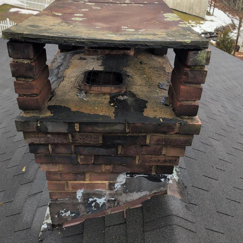 Brick chimney with damaged mortar and rusted cap plate Brick chimney with damaged mortar and rusted cap plate